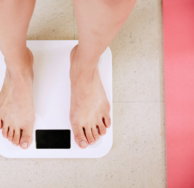 person standing on white digital bathroom scale
