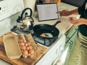 Person cooking eggs on a stovetop following a recipe.